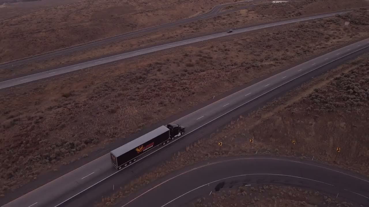 A semi-truck climbing a mountain highway
